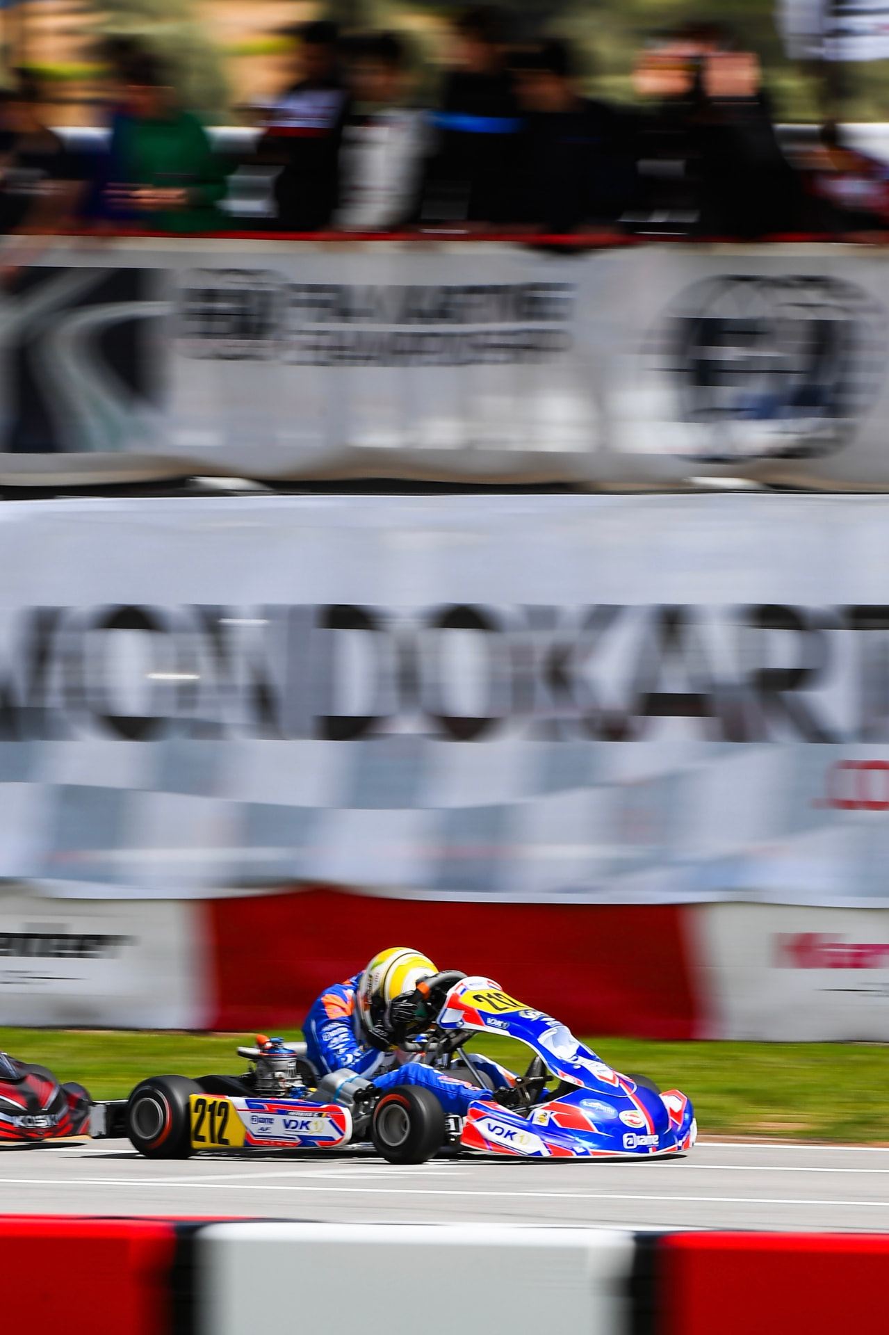 Kart 212 racing past the grandstand